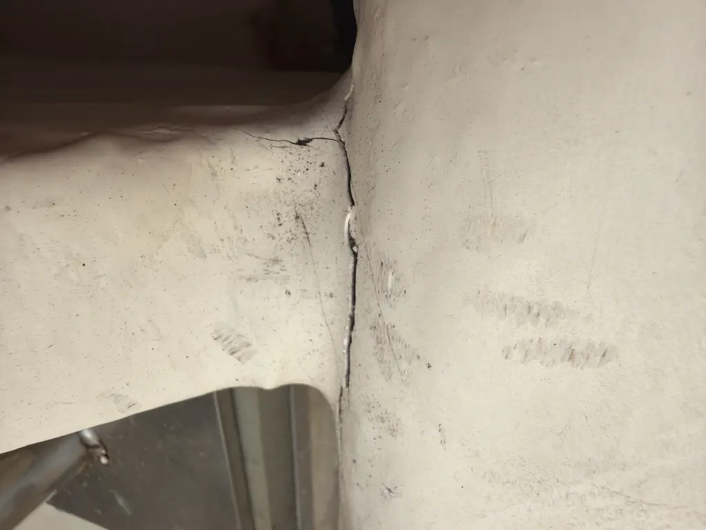 A crack running through a fibreglass hull structure, photographed during a damage survey